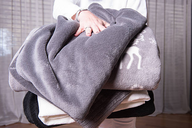 female helper welcomes refugees with warm blankets for cold nights