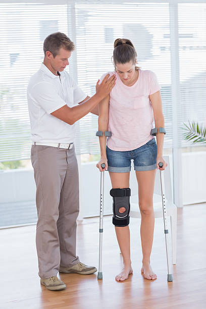 istock Doctor helping his patient walking with crutch 490879466