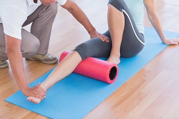 istock Trainer working with woman on exercise mat 490879840