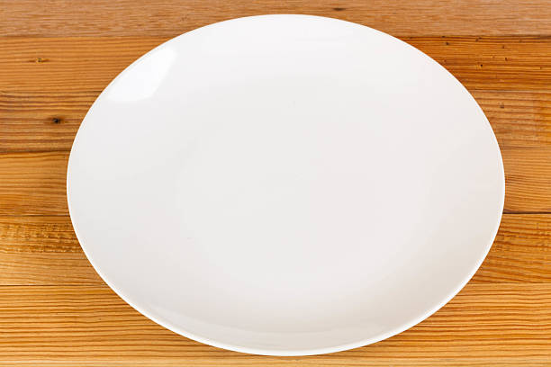 istock white ceramics plate on wood background 490880208