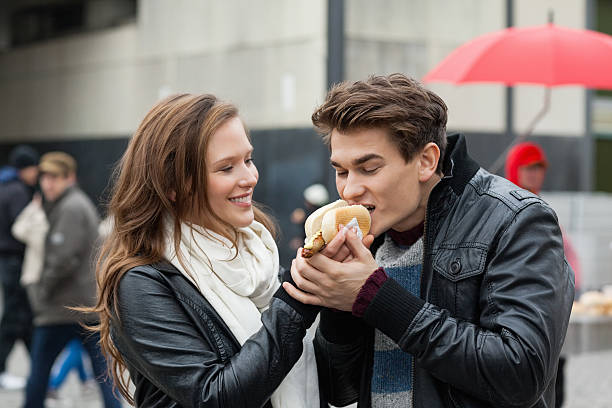 istock Woman Feeding Hotdog To Man 490880733