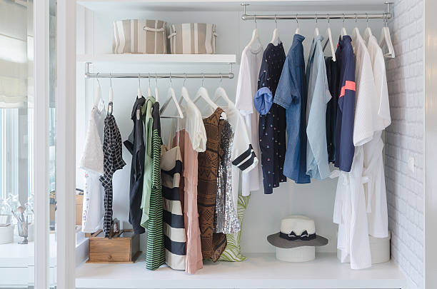 clothes hanging in closet with hat stock photo