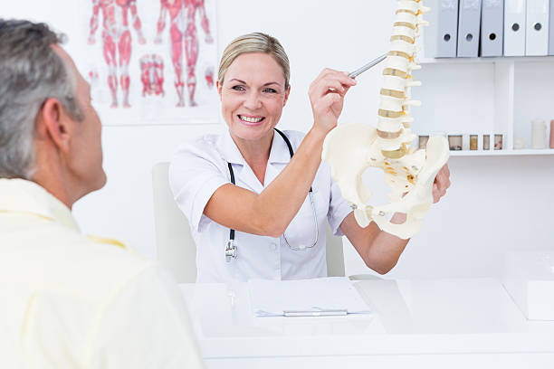 istock Doctor showing her patient a spine model 490881880