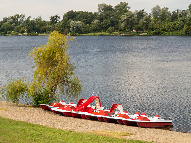 Red pedaloes on the lake shore stock photo