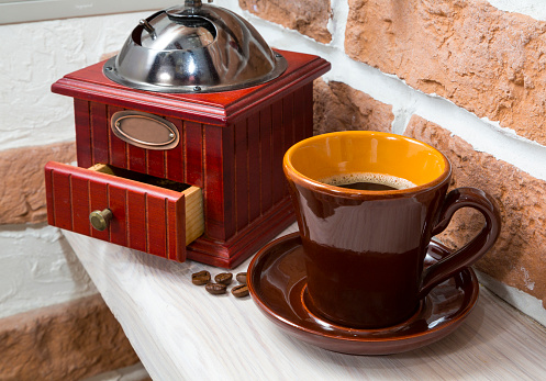 cup of coffee, coffee grinder, still life on a background wall. interior