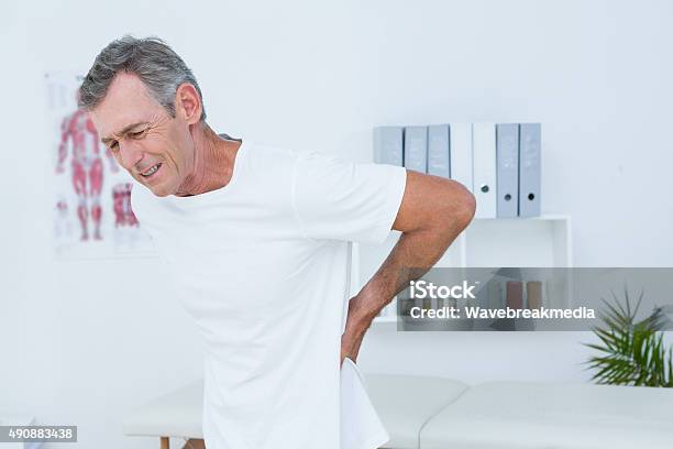 Suffering Patient Touching His Back Stock Photo - Download Image Now - Backache, Mature Men, Adult
