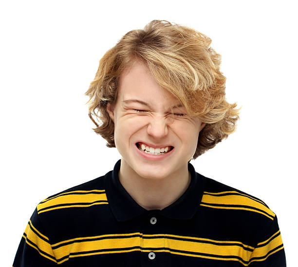 .Angry teenage boy grinding teeth in extreme rage .Angry teenage boy grinding teeth in extreme rage clenching teeth stock pictures, royalty-free photos & images