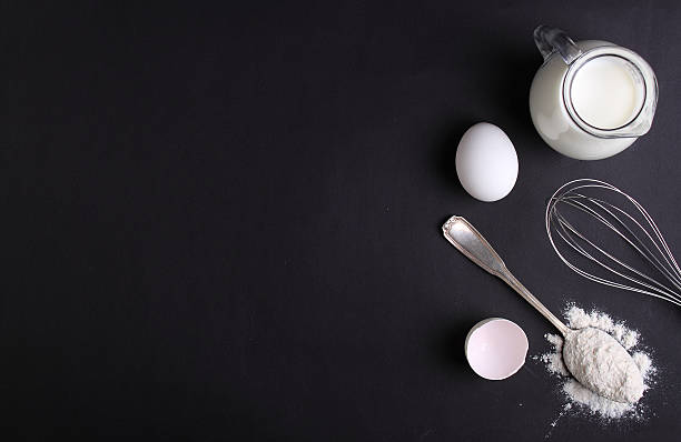istock eggs, flour, milk and whisk on a dark background 490884162