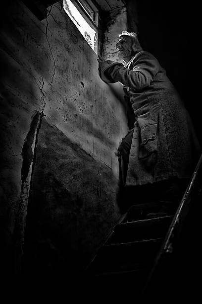 istock Man at the top of stairway looking through a window 490884504