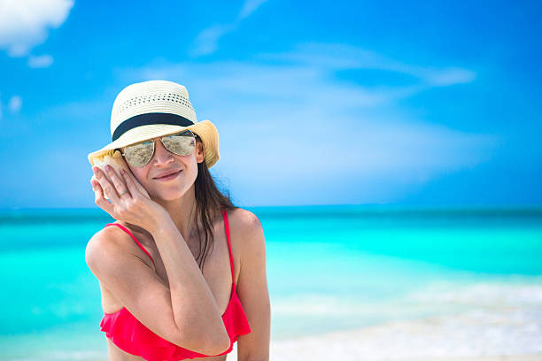 istock Beautiful girl with seashell in hands at tropical beach 490884889