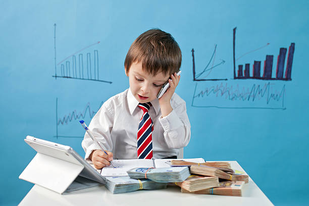 Young boy in tie with phone, notebook and money