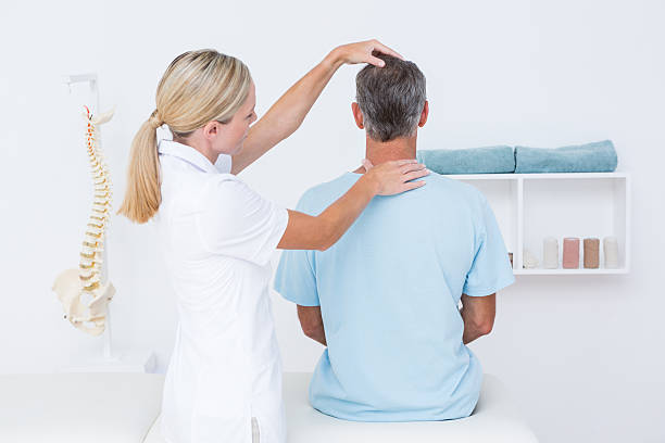 doctor doing neck adjustment - menselijke nek stockfoto's en -beelden