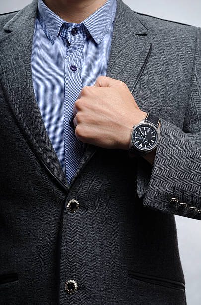 istock man in a suit shows a wristwatch 490886618