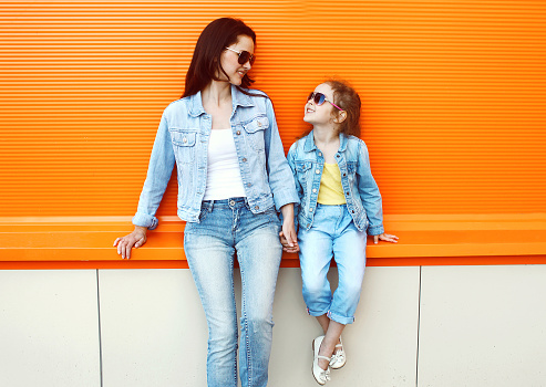 Happy mother and child wearing a jeans clothes in city