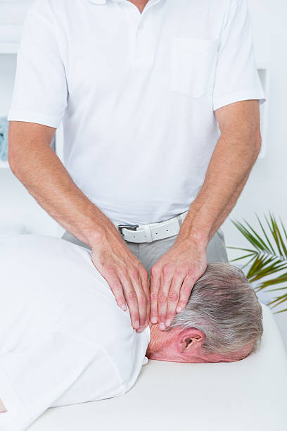 istock Physiotherapist doing neck massage to his patient 490891618