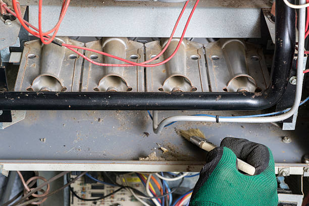 técnico usando un cepillo para limpieza en quemadores - air conditioner electricity repairing furnace fotografías e imágenes de stock