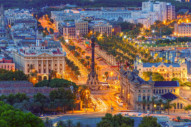 Mirador de Colom at night, Barcelona, Spain Aerial view over square Portal de la pau, and Port Vell marina and Columbus Monument at night in Barcelona, Catalonia, Spain la rambla stock pictures, royalty-free photos & images