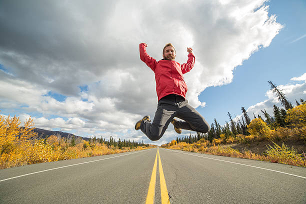 istock Cheerful traveler jumping high up on road 490910016