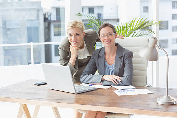 istock Smiling businesswomen looking at camera and working together 490913908