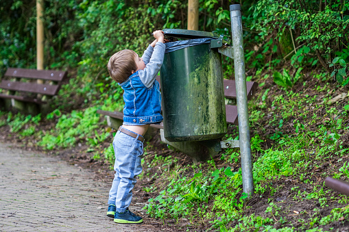 Little child throwing trash in the bin