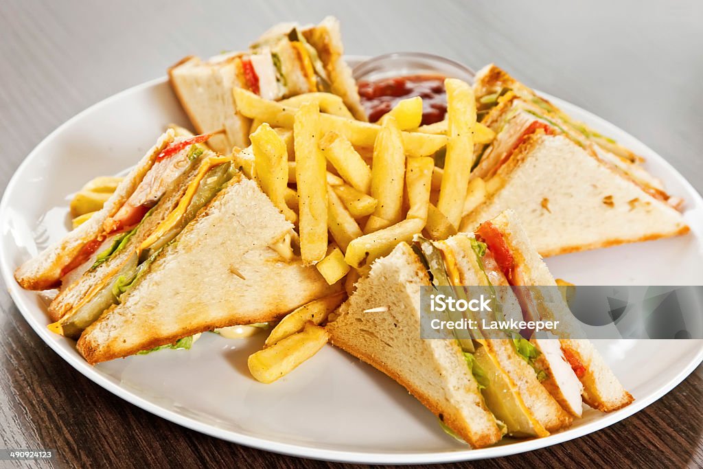 Clubhouse sandwich Sandwich with salad, bacon, deep-fried potatoes, pickled cucumber and cheddar sauce American Culture Stock Photo