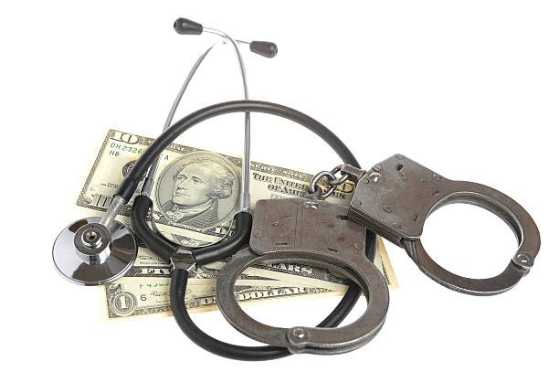 istock Stethoscope, handcuffs and money on white background 490926001