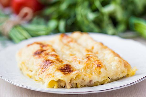 Italian pasta Cannelloni stuffed with meat, white Bechamel sauce stock photo