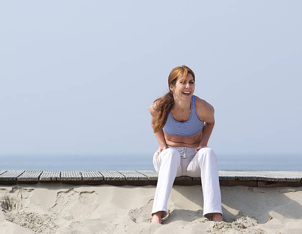 Mature woman laughing at the beach