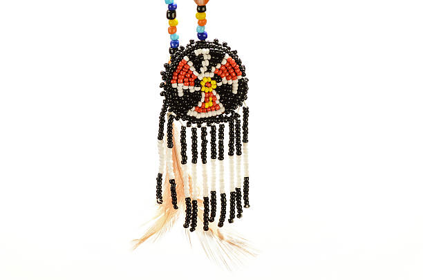 Beaded Native American Symbol Closeup of beaded Native American Thunderbird Medallion against white background.  Thunderbird is powerful spirit related to storms and thunder. symbol north american tribal culture bead feather stock pictures, royalty-free photos & images