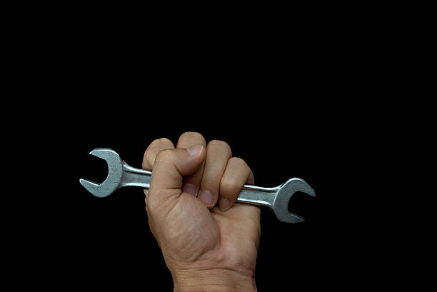 istock hold wrench in your hand and in black background 490932916
