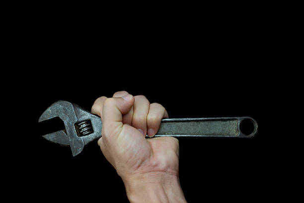istock hold wrench in your hand and in black background 490932960
