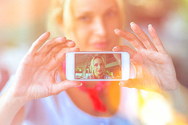 istock Young woman using smartphone to take selfie at the cafe 490938604