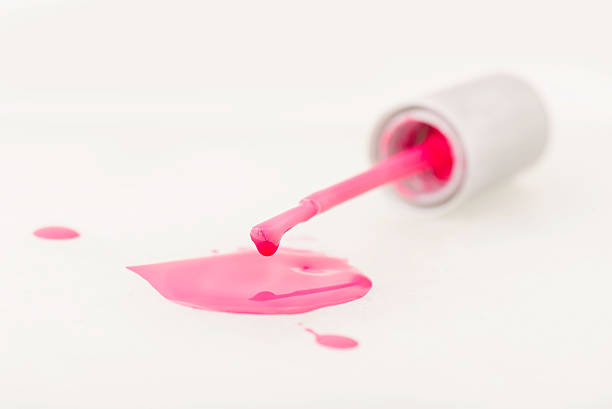 istock Spilled pink nail polish with brush on isolated background 490939352