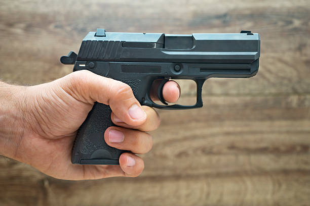 istock Masculine hand holding pistol gun 490940784