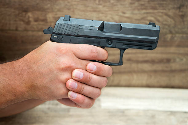 istock Masculine hand holding pistol gun 490941918
