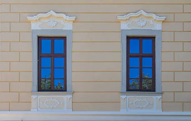 Two renewed windows on the old manor-house in Bernolakovo, Slovakia. Reflection of the bright blue sky.