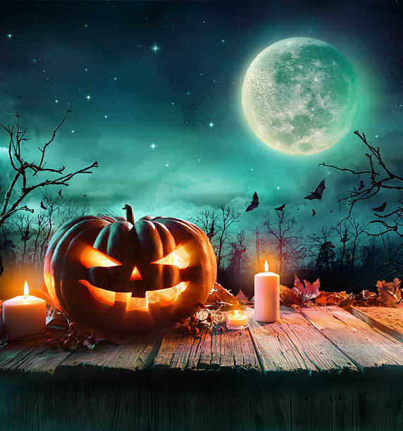 Halloween Pumpkin In A Scenic Night Halloween Pumpkin On Wooden Plank With Candles In A Spooky Night halloween pumpkin jack o lantern horror stock pictures, royalty-free photos & images