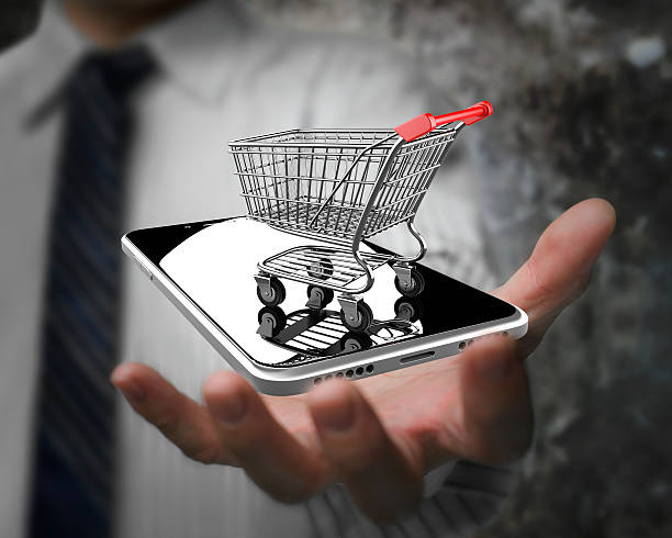 Businessman hand showing shopping cart with smart phone stock photo