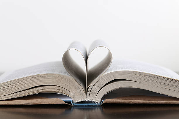 istock Open book on wood table over white background. Pages folded 490958182