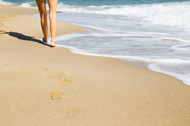 istock Woman walking on the beach 490958484