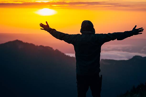 istock Man Traveler hands raised silhouette outdoor 490959120