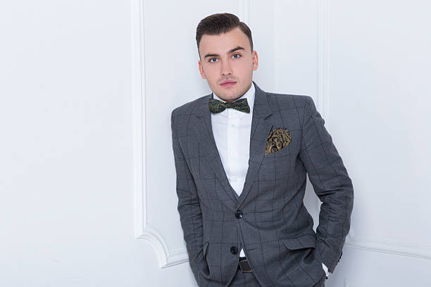 istock Stylish man in a gray suit with butterfly tie standing 490959822