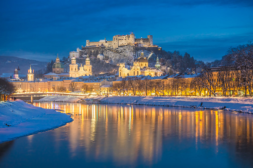 Beautiful view of the historic city of Salzburg with Salzach river in winter during blue hour, Salzburger Land, Austria