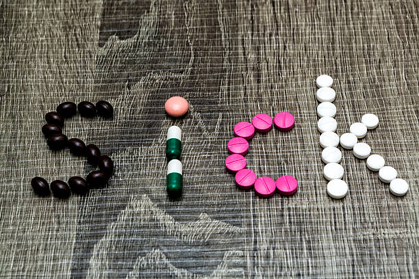 istock The word sick written whith pills on a wooden background. 490964936