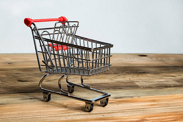 istock Empty miniature shopping cart on wooden table 490968432