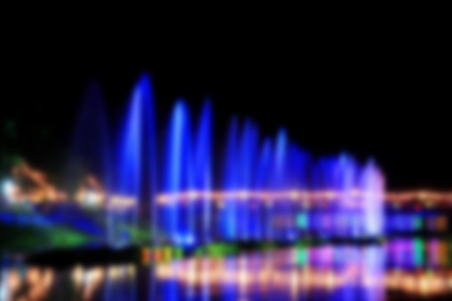 blur image. Water fountains on night background in Thailand. Dancing water fountains. Colourful water fountains show