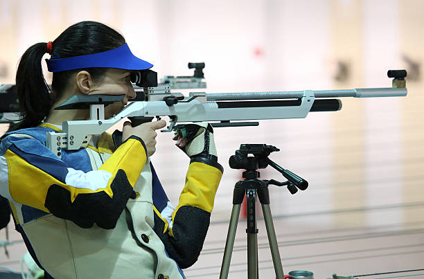 woman aiming a pneumatic air rifle beautiful young woman aiming a pneumatic air rifle target shooting stock pictures, royalty-free photos & images