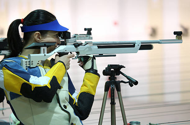 женщина, aiming a пневматические воздуха rifle - rifle range стоковые фото и изображения