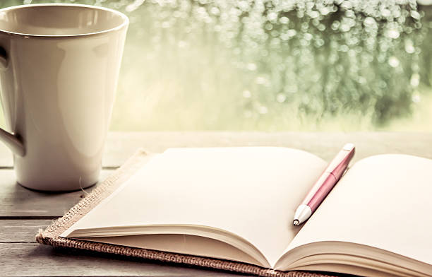 Pen on open notebook and coffee cup stock photo