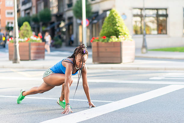 piękne afryki sportowy kobieta gotowy do uruchomienia na ulicy. - athlete sport starting line muscular build zdjęcia i obrazy z banku zdjęć